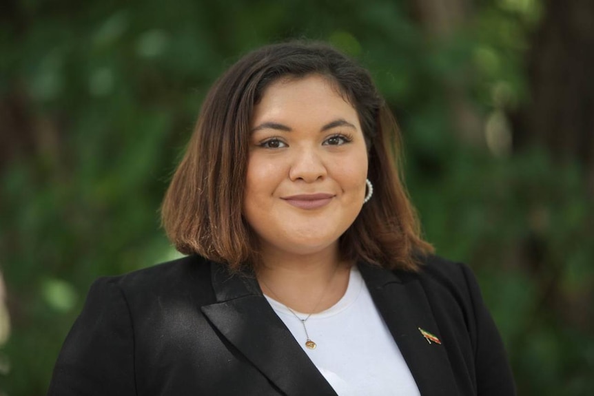 A headshot of a young woman with short brown hair