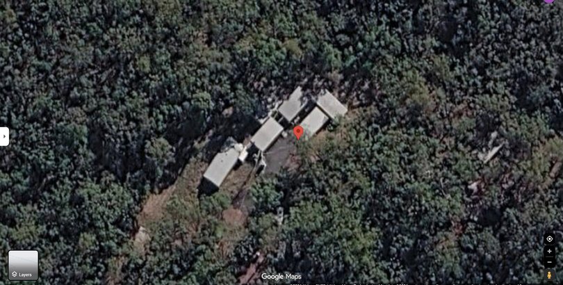 Satellite imagery shows a cluster of buildings within dense bushland near Canungra, Queensland, where interrogation training exercises have been conducted.