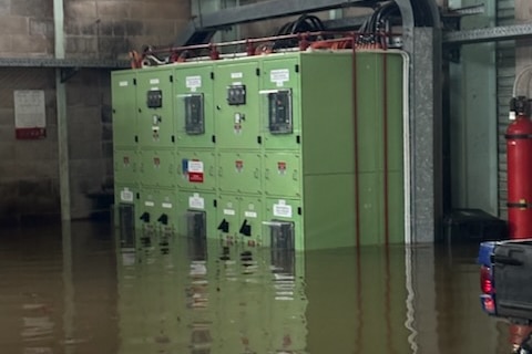 A green machinery cabinet with water rising around it