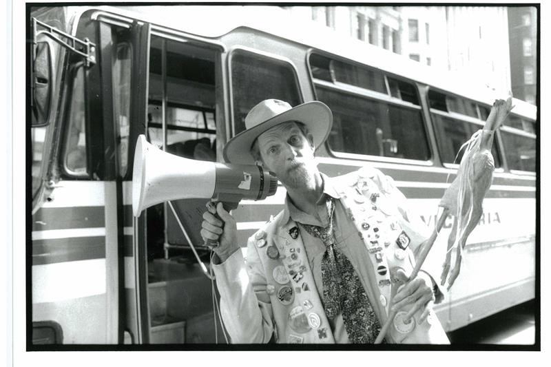 Rod Quantock holds a megaphone and a stick with a chicken on it.