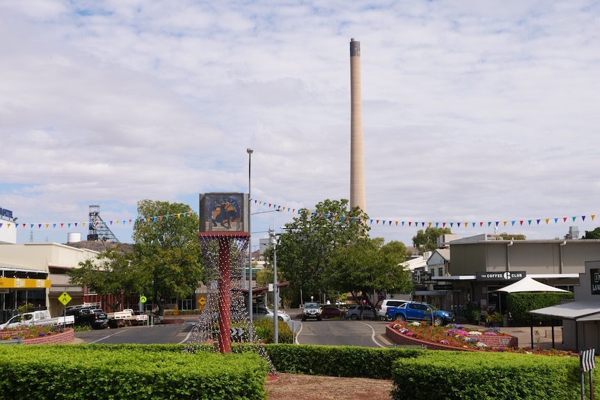 shot of mount isa's cbd with a tall chimney in the background and the main traffic roundabout.