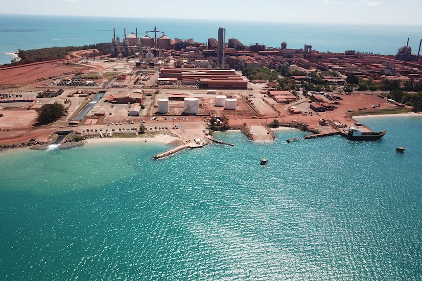 Gove refinery from the air showing a mining site surrounded by bright blue ocean.
