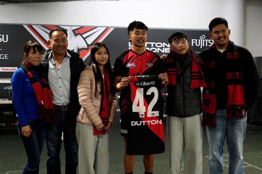 Asian footballer with his family holding jersey with Number 42