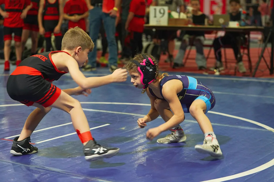 Lucy Milgrim, 9, right, prepares to take on a component during a wrestling match. Lucy went viral on social media in March 2026 for a video of her deadlifting 180 pounds.