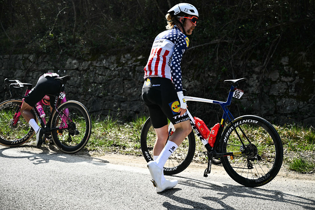 Lidl-Trek's US Quinn Simmons stands on the side of the road as he has a mechanical issue during the 20th one-day classic 'Strade Bianche' (White Roads) men's cycling race between Siena and Siena in Tuscany on March 7, 2026. (Photo by Marco BERTORELLO / AFP)