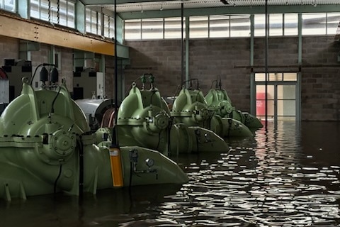 Green machinery with water rising around it