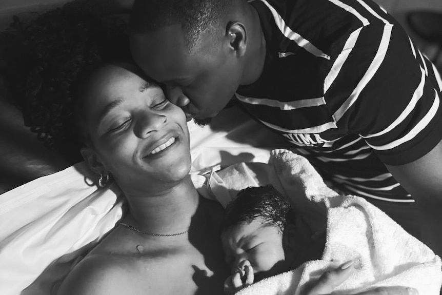 Two parents pose for a photo after the birth of their son