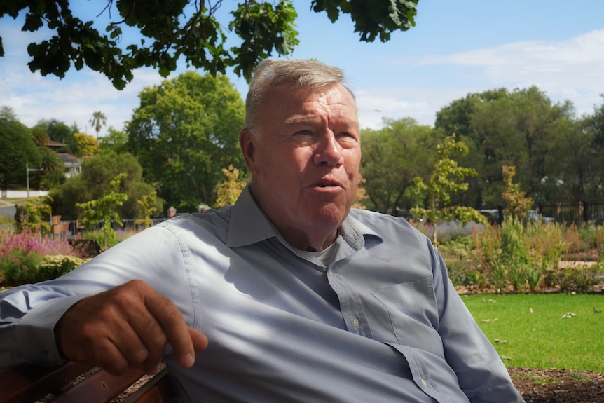 David Farley speaks while reclining on a park bench.