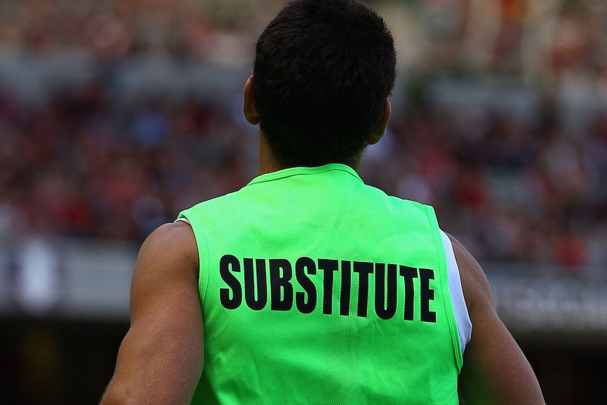 An AFL player in the substitute vest.
