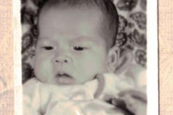 A close up of a baby from a passport photo