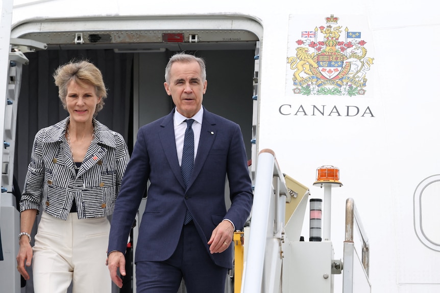 Canadian Prime Minister Mark Carney reacts as he and his wife, Diana Fox Carney, arrive in Sydney