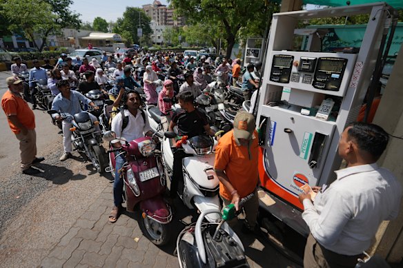 Motorists queue up to get fuel at a pump in Ahmedabad, India, this week.