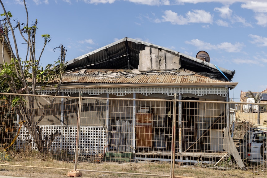 A damaged house that is fenced off