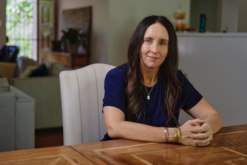 Sydney fashion designer Katie Jane Taylor, who owns the fashion label Katie Perry, straight faced sitting at table