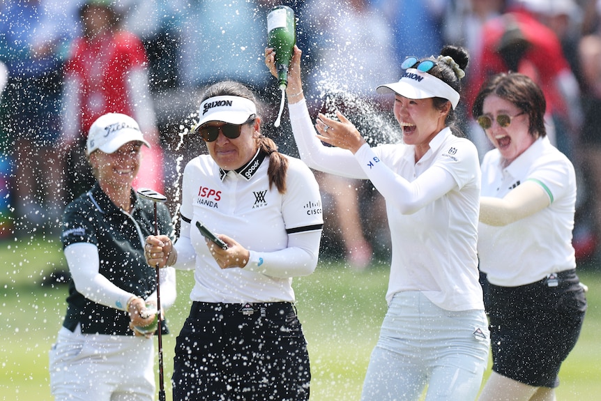 Hannah Green is showered in sparkling wine after winning Women's World Championship.
