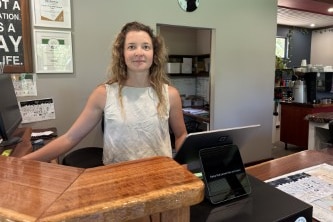 Woman with curly hair standing at desk 