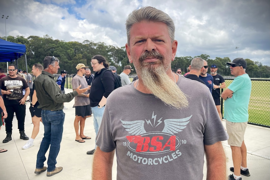 A man with a long grey beard looks towards the camera.
