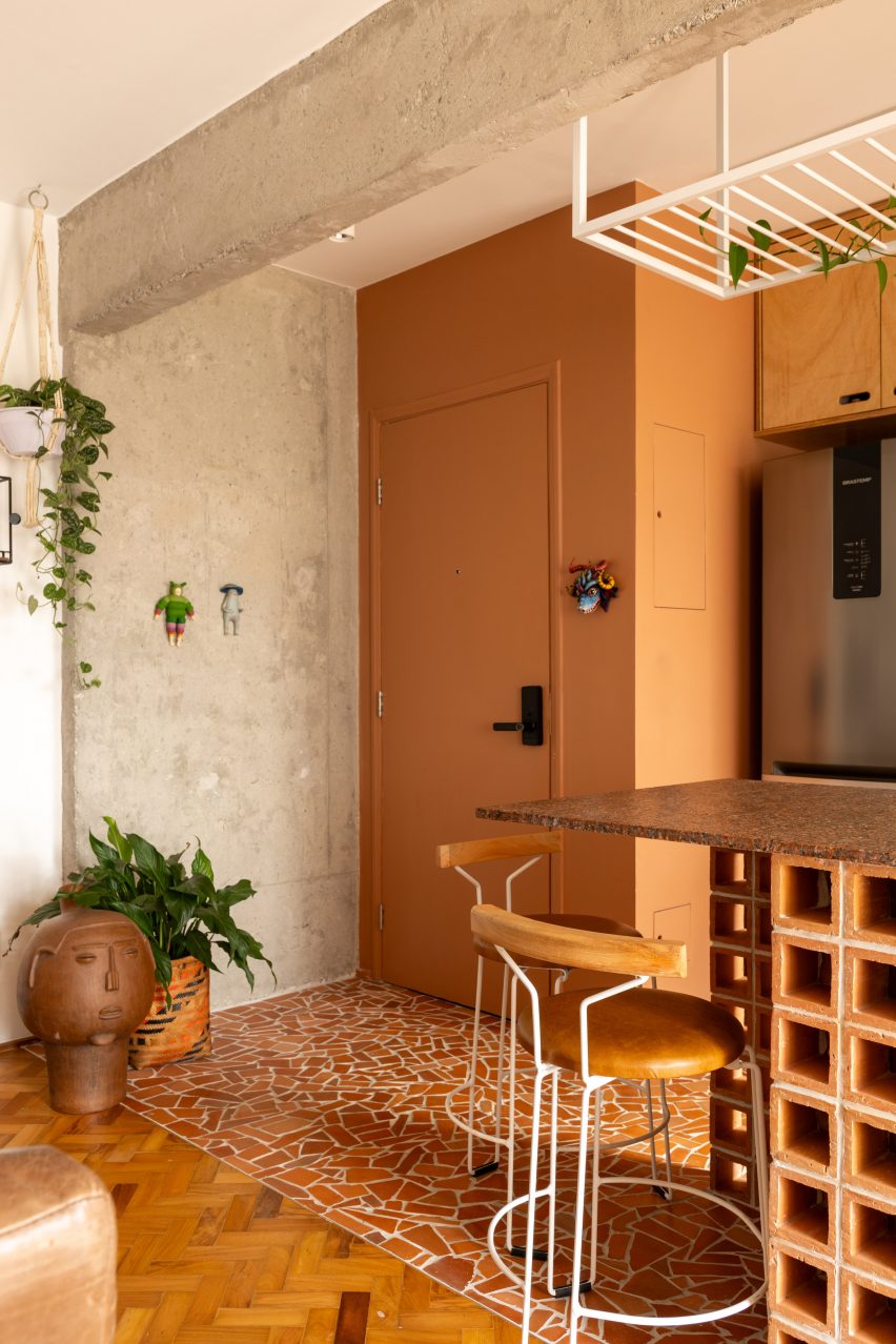 Apartment entry with terracotta-painted and exposed concrete walls