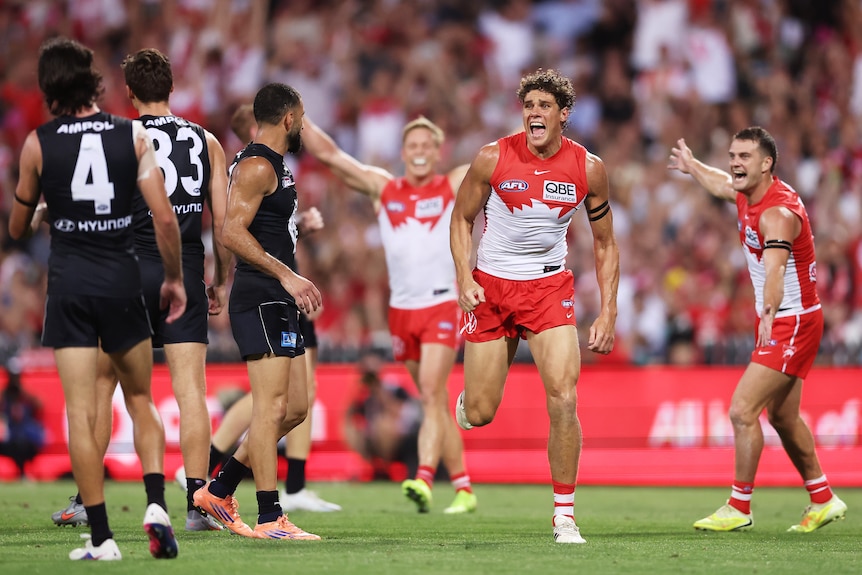 Charlie Curnow celebrates a goal as Carlton players watch on