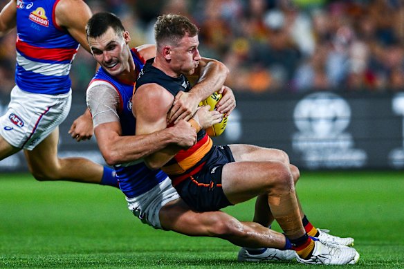 Rory Laird of the Crows tackled by Sam Darcy of the Bulldogs.