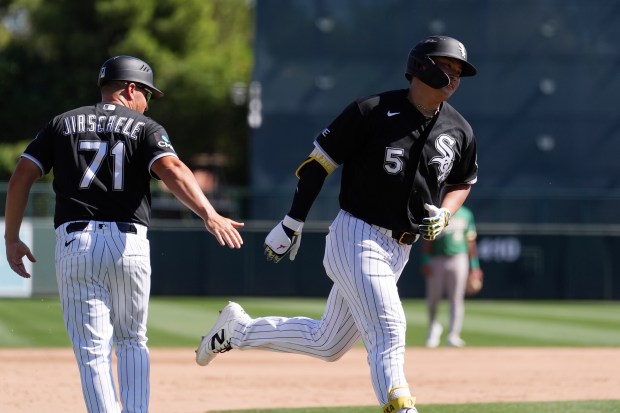 Chicago White Sox's Munetaka Murakami slaps hands with White Sox third base coach Justin Jirschele as Murakami rounds the bases after hitting a home run against the Athletics during the fifth inning of a spring training baseball game, Tuesday, March 17, 2026, in Glendale, Ariz. (AP Photo/Ross D. Franklin)