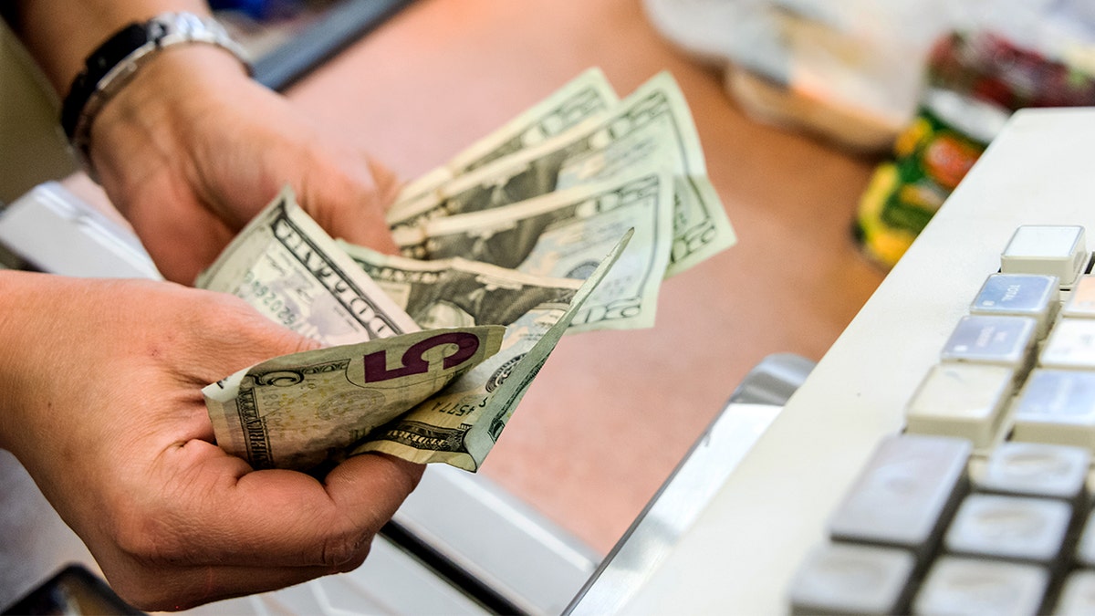 A cashier holds cash.