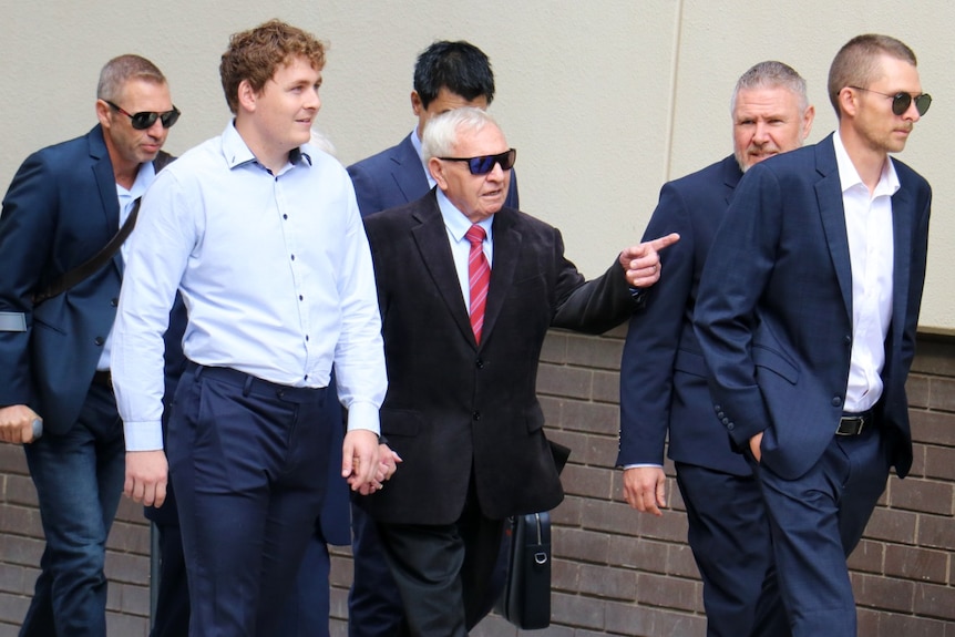 Barry Cable points as he is surrounded by supporters as he walks to court