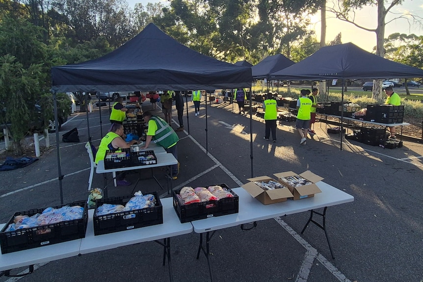Volunteers from Cos We Care setting up tables of food.