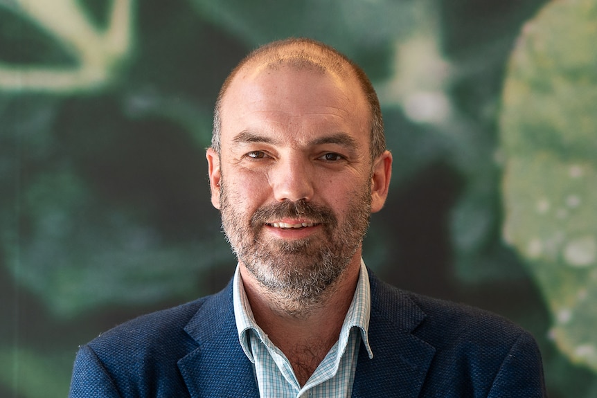 A man in a suit smiling