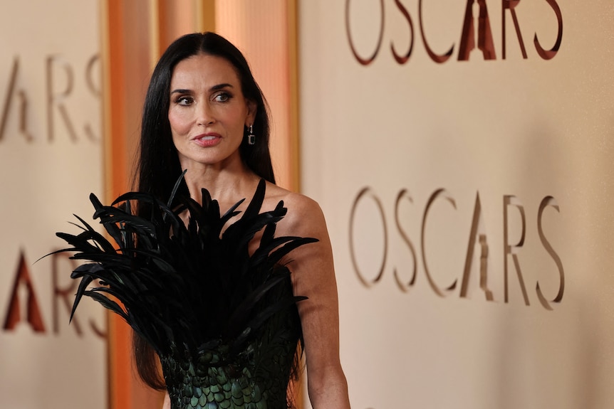 Demi Moore in a eathery green scaly dress