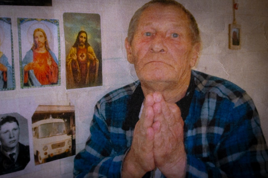 A man in a checked blue shirt holds his hands together in prayer with images of Jesus beside him