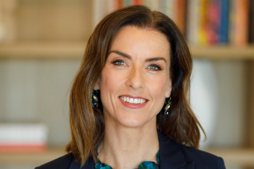 Kellie smiles and poses for a professional headshot.