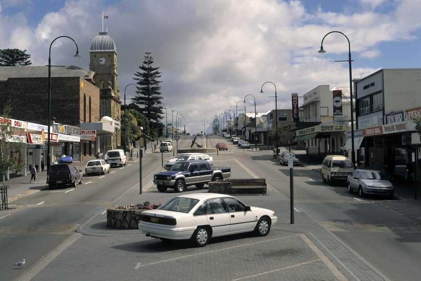 Cars parked on a town main street in the 1990s.