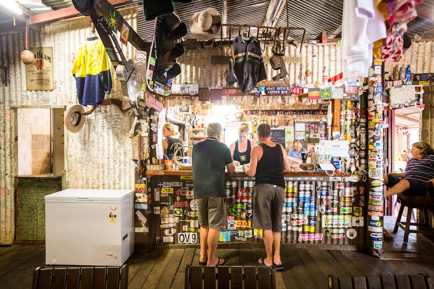 A woman serves drinks behind a bar 