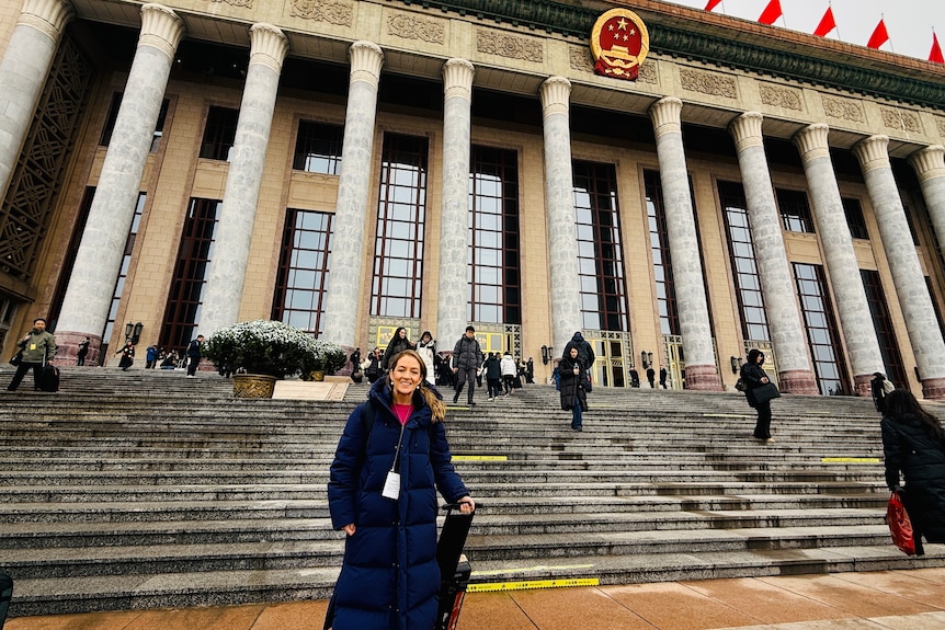 woman in front of pillared building.