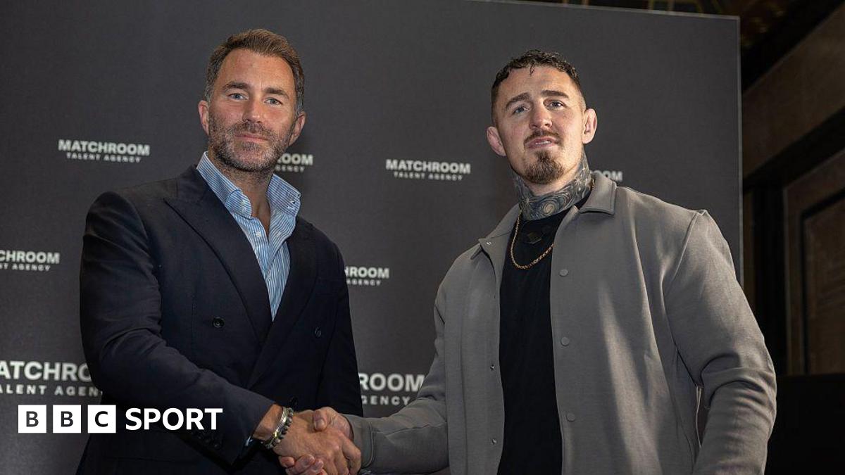 Eddie Hearn and Tom Aspinall shake hands and look at the camera