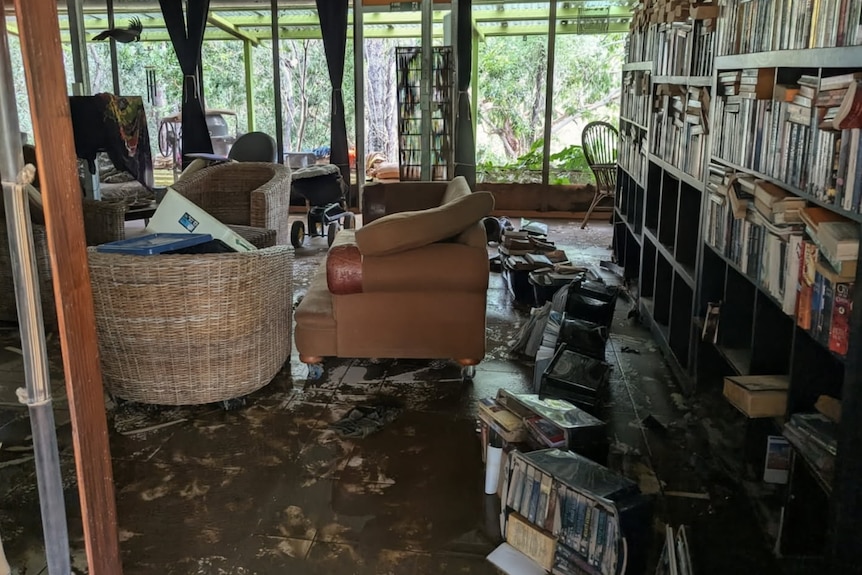 A messy living room full of flood-damaged items.