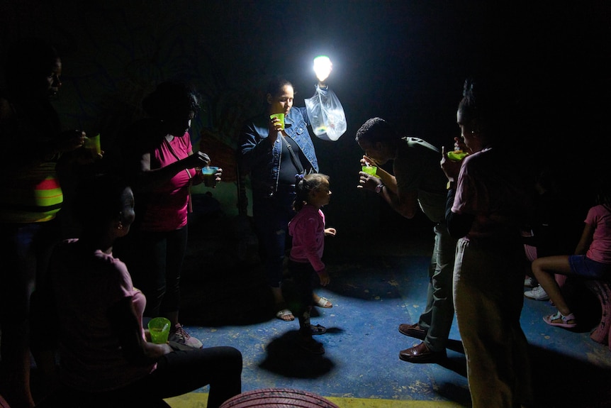People eat cups of soup outside during a blackout in Havana, Cuba.