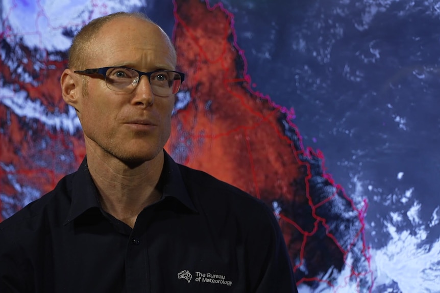 Headshot of man before a map.