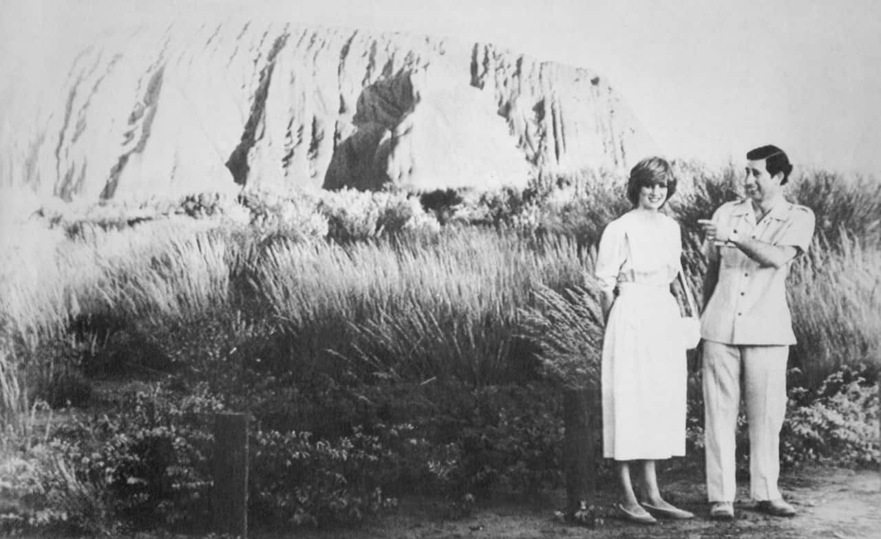 A black and white photo of a man and a woman with a mountain in the background