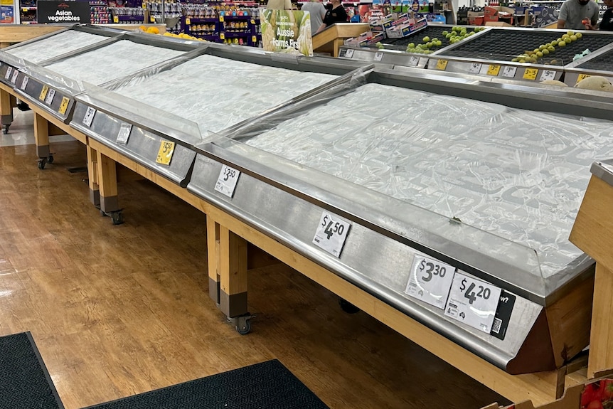 A bare produce display inside a grocery store.