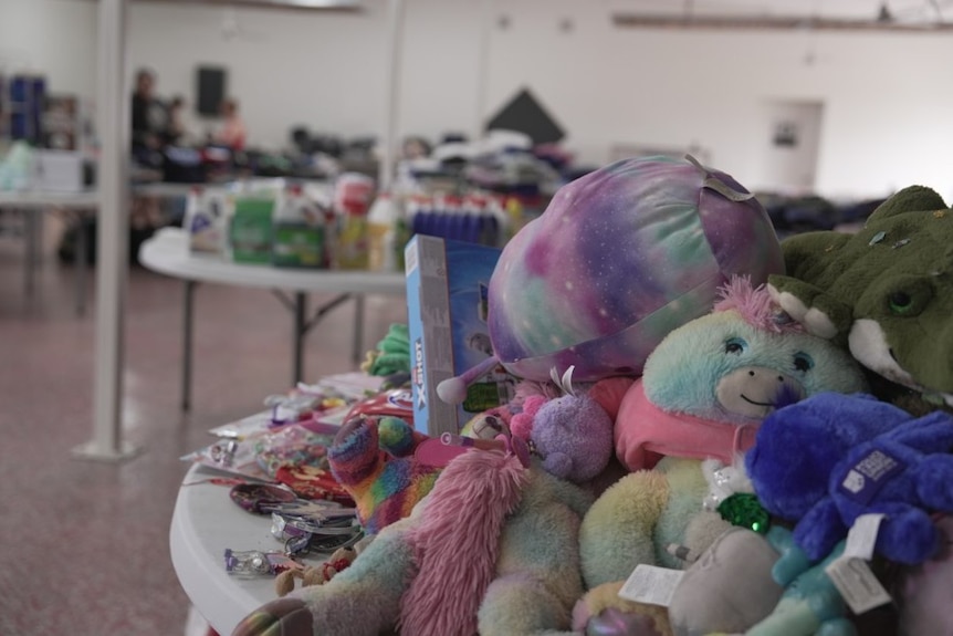 A large room with tables laden with soft toys and blankets.