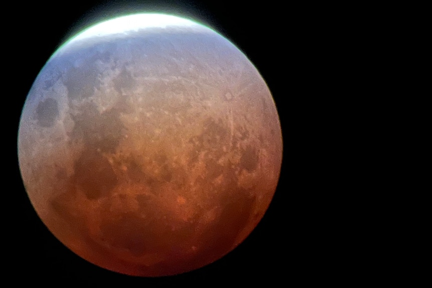 Close up image of the moon with a white, blue and red gradient