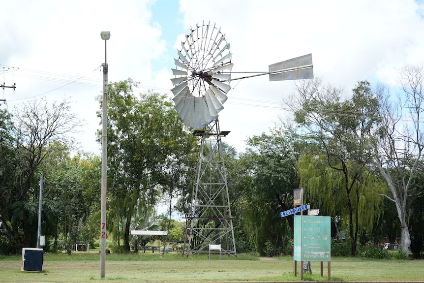 A white windmill surrounded by trees