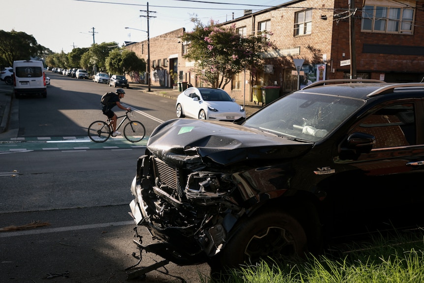 a parked car with a crumpled front parked on a street