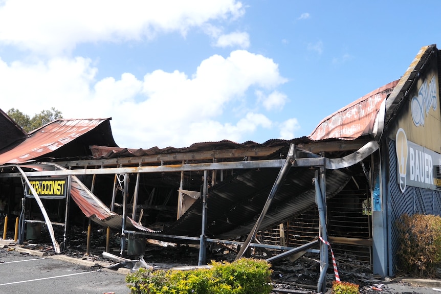 A wide shot of a building covered in tape and burnt. 
