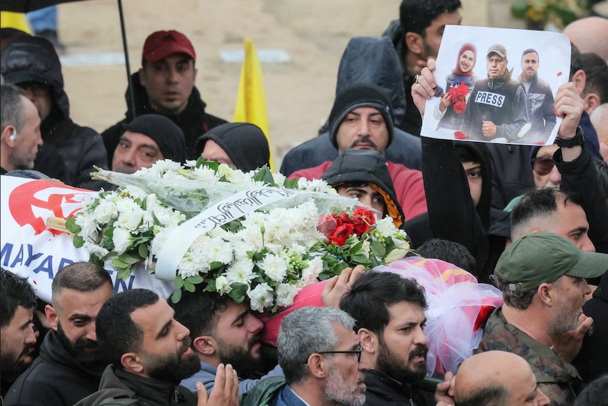 Mourners carry the body of one of the journalists killed in the Israeli strike in south Lebanon during their funeral