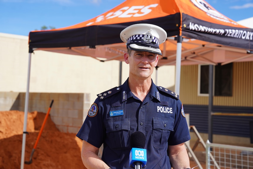 A policeman stands near an SES-branded marquee.