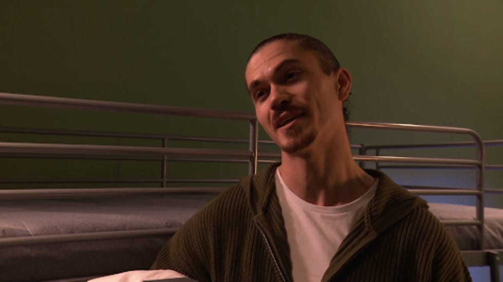 individual in a dormitory setting with bunk beds in the background