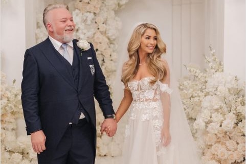 a groom and a bride holding hands and smiling